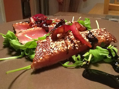 tonno rosso scottato in crosta di sesamo con cipolla rossa carammellata e riduzione di aceto balsamico su letto di rucola