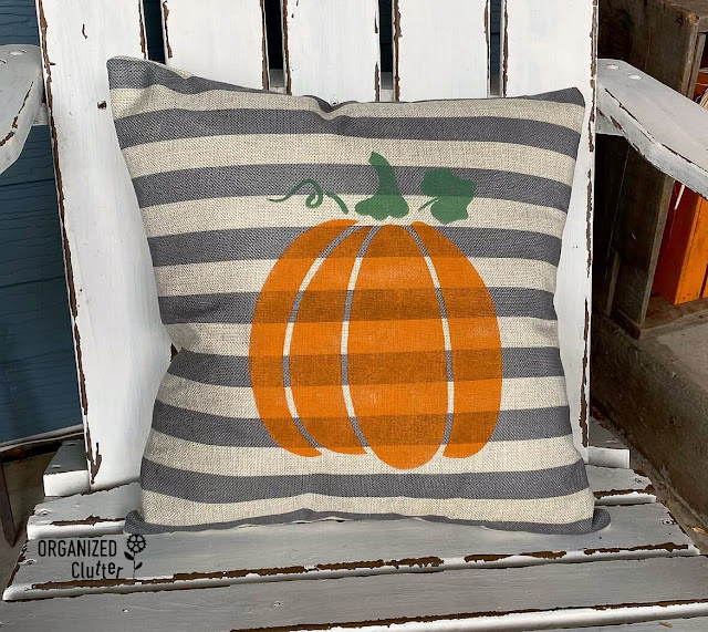 Photo of a striped pillow with fall pumpkin stencil.