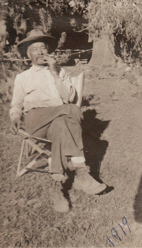 Charley Lee Blasingame smoking outside his house at China Camp, circa 1919.