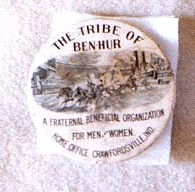 A button reading: The Tribe of Ben-Hur: A fraternal beneficial organization for men and women, home office Crawfordsville, Ind." The button has a sketch of a chariot race on it.
