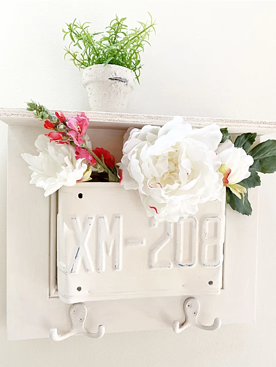 License plate shelf with hooks filled with flowers
