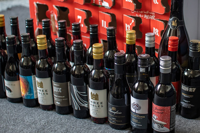 The virgin wines advent calendar with all doors open and 25 bottles in front of it