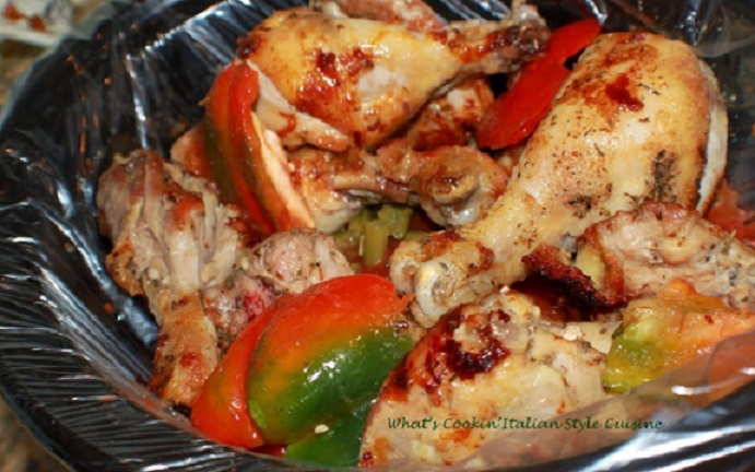 slow cooker chicken cacciatore in a large black liner pot with peppers on top