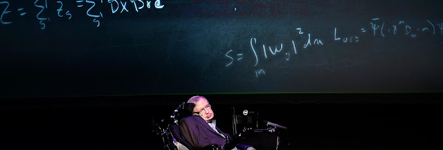 Physicist Stephen Hawking in front of a blackboard with equations