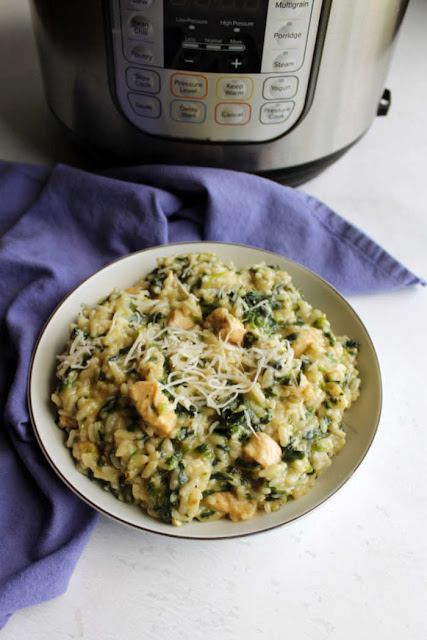 Creamy delicious risotto with chicken and spinach stirred right in sounds complicated, but it's super simple with the help of an instant pot. bowl of creamy spinach and chicken risotto with cheese on top in front of instant pot