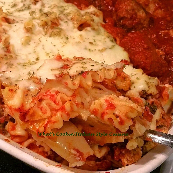 Mom's Lasagna Recipe this is a lasagna pasta layered with meat sauce and melted mozzarella cheese on a white dish with meatballs and sausage