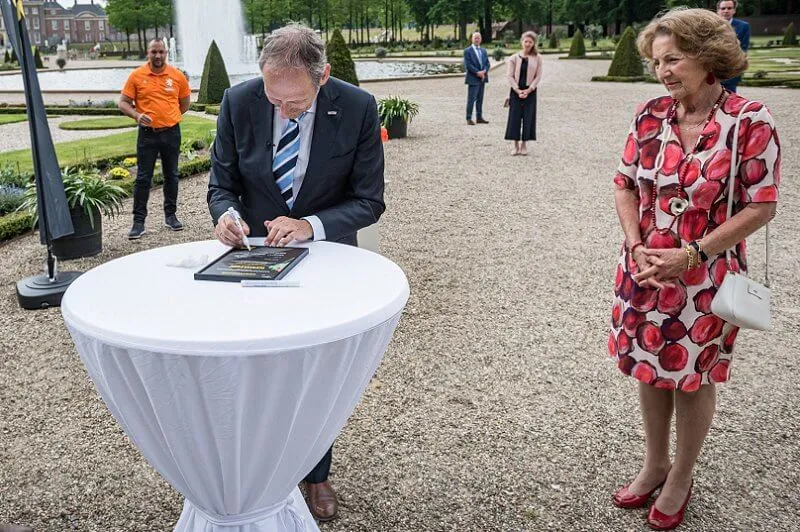 Princess Margriet wore a red floral print dress and red pumps, carried white bag
