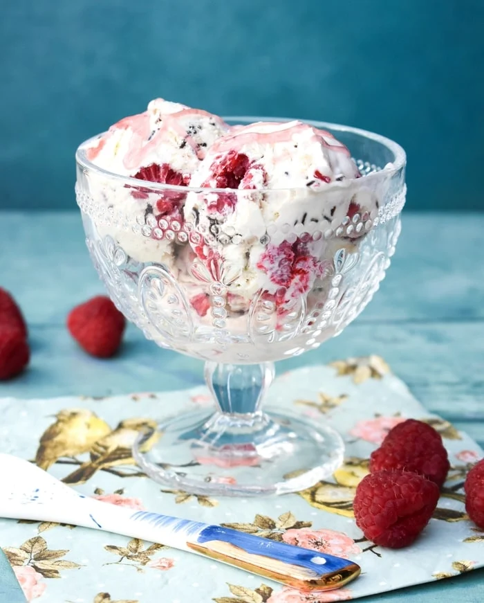 raspberry ripple ice cream in a sundae dish topped with strawberry syrup