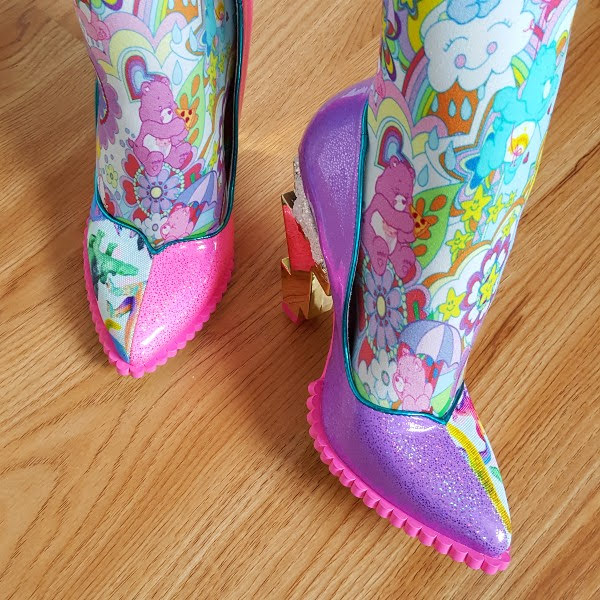 close up of feet showing pink and purple glitter patent side of shoe against dinosaur uppers