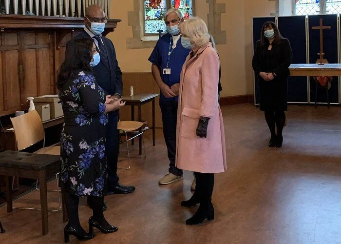 The Duchess met with those involved in the vaccination process, including NHS staff, volunteers and representatives. Pink wool coat and black boot