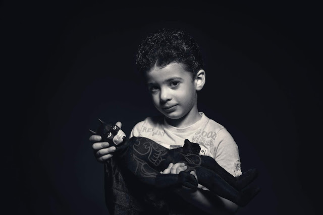 Boy  holding a Batman plush toy