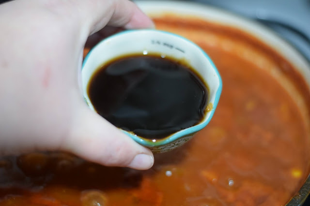 The soy sauce being added to the pot.