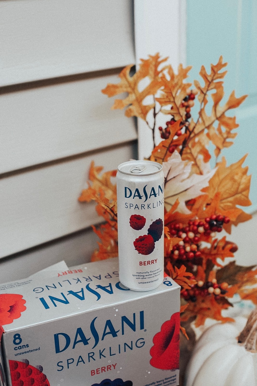 Fall Porch Decorating with Dasani Sparkling Water. Tampa Blogger, Amanda Burrows, Affordable by Amanda shares her fall porch decoring leaves and white pumpkins. She is also drinking Dasani Sparkling Berry sparkling water while she decors the front porch for fall. 