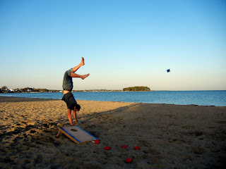 Tossing a bean bag with his toes while doing a handstand on the beach!