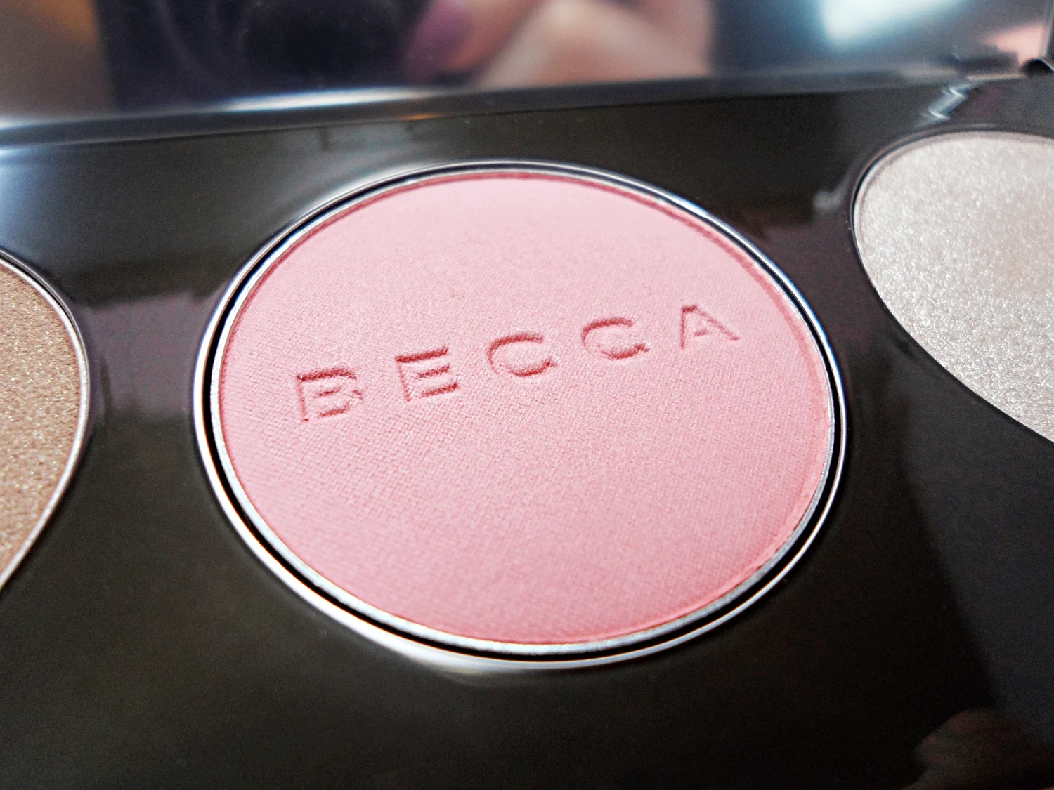 close-up of makeup contouring palette by Becca Cosmetics on a studio's rosy background