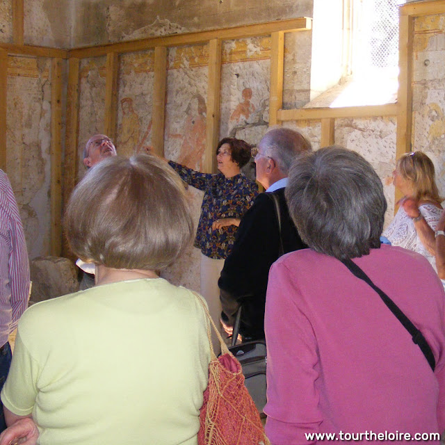 A conservator shows visitors medieval wall paintings in the Chapelle de Tous les Saints, Preuilly sur Claise, Indre et Loire, France. Photo by Loire Valley Time Travel.