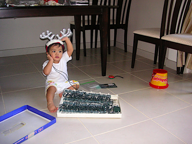 Kecil in reinderr headband, playing with the Christmas lights