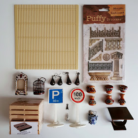 Flat lay of various 1/12 scale miniature items including an oak coffee table, peruvian pots, pallets, road signs, and puffy stickers.