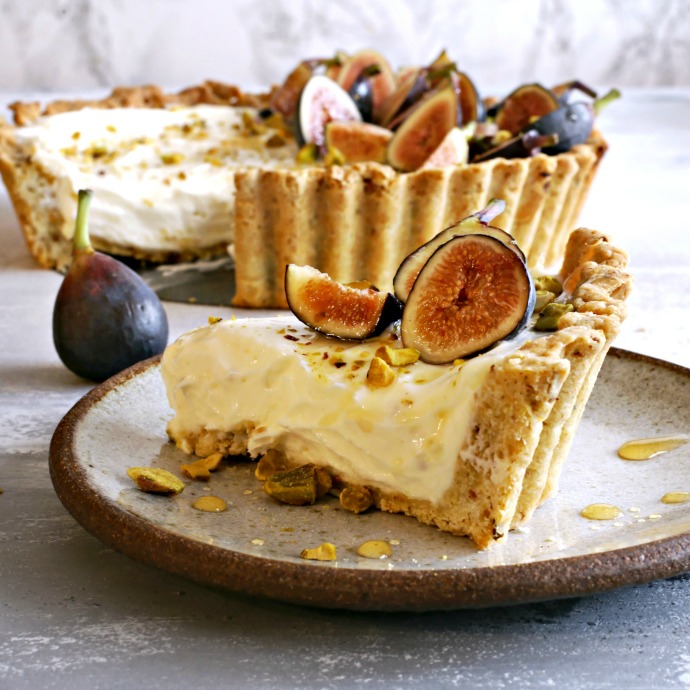 Recipe for a tart with pistachio crust, no-bake cheesecake filling and honey glazed figs.