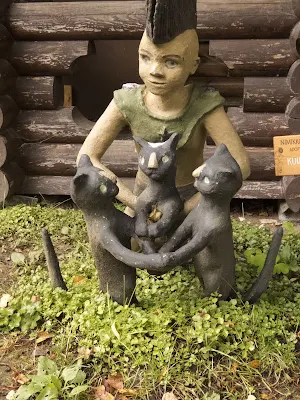 Kid with a mohawk and 3 cats at Parikkala Sculpture Park in Finland