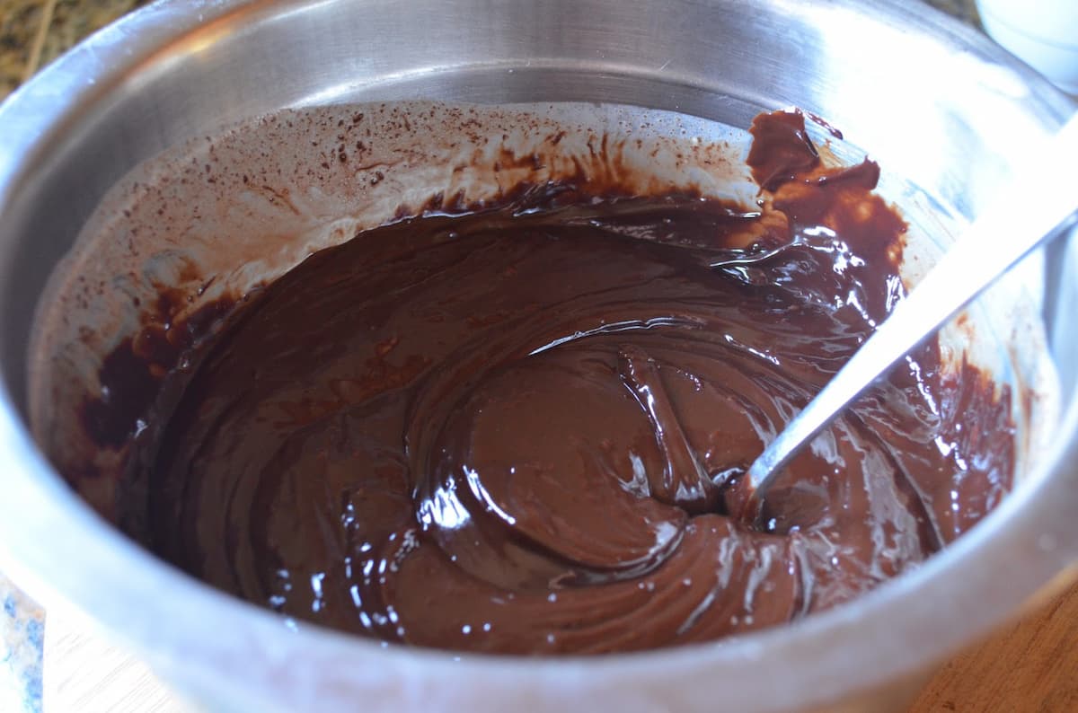 Melted Chocolate Ganache in a stainless steel mixing bowl.