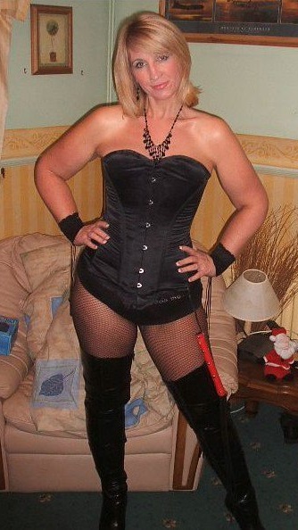 Sexy strict Mistress in corset, fishnets and boots