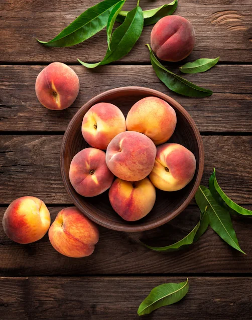 bowl of peaches on wooden boards