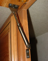 cabinet door supported by strut