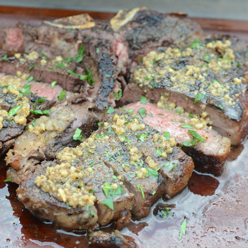Grilled porterhouse steak with green peppercorn and garlic butter