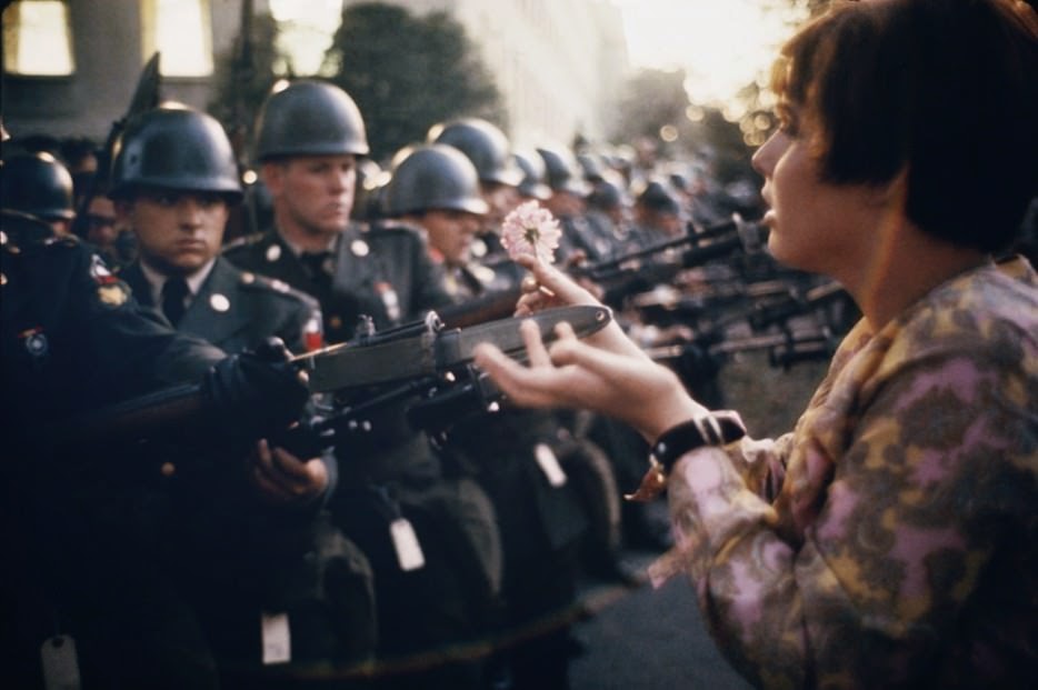 17 year old Jan Rose Kasmir offers a flower to soldiers during the Pentagon anti-war protest in 1967. - The 63 Most Powerful Photos Ever Taken That Perfectly Capture The Human Experience