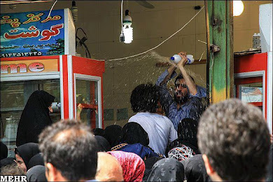 پاشیدن آب بر روی شهروندان متقاضی مرغ دولتی برای جلوگیری از ازدحام
