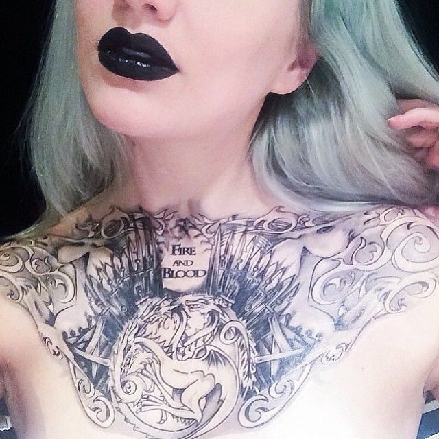Mujer de frente, lleva en el pecho un tatuaje grande, el tatuaje es de juego de tronos