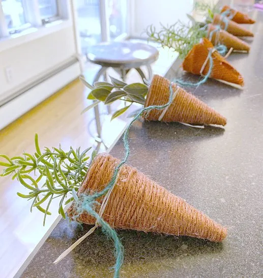 Attaching carrots to a length of jute for hanging