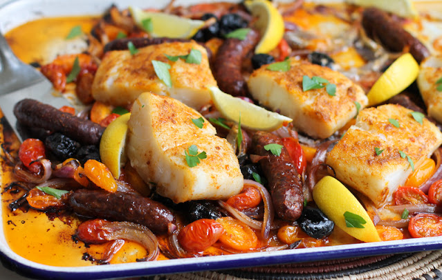 This Spicy Cod and Merguez Traybake is a lovely combination of mild and spicy, flaky and chewy, a tasty way to enjoy both cod and merguez in one dish, not to mention fresh tomatoes and salty olives.