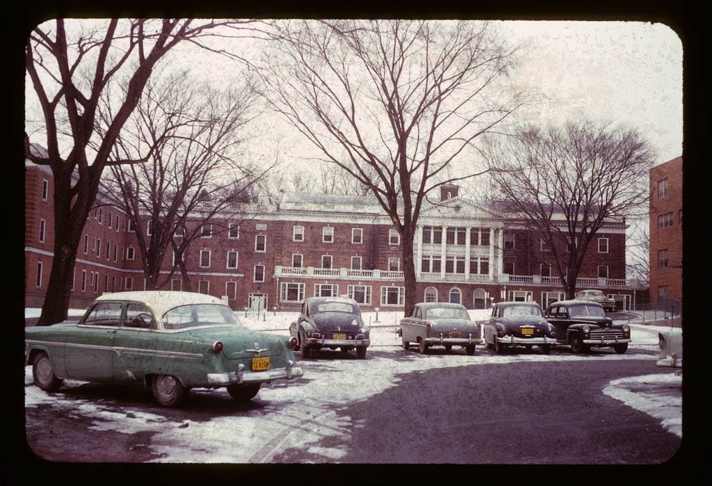 Classic cars in a building yard in Rochester, NYC, ca. 1950s vintage