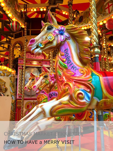 A merry go round with colourful decorated sculpted horses, one with the name Dorothy.