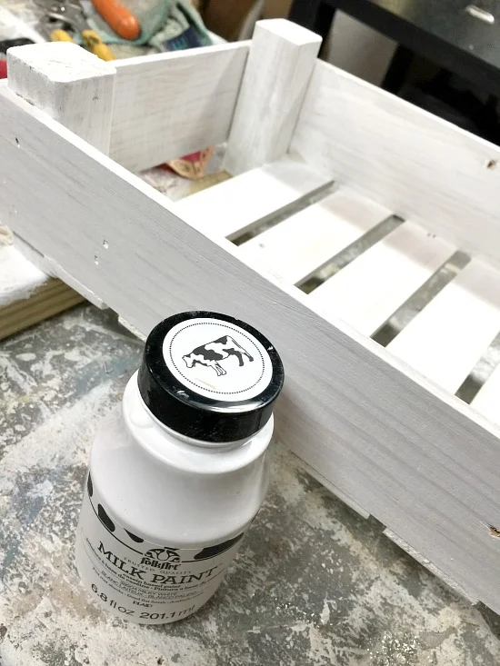 Painting a wooden crate with white milk paint