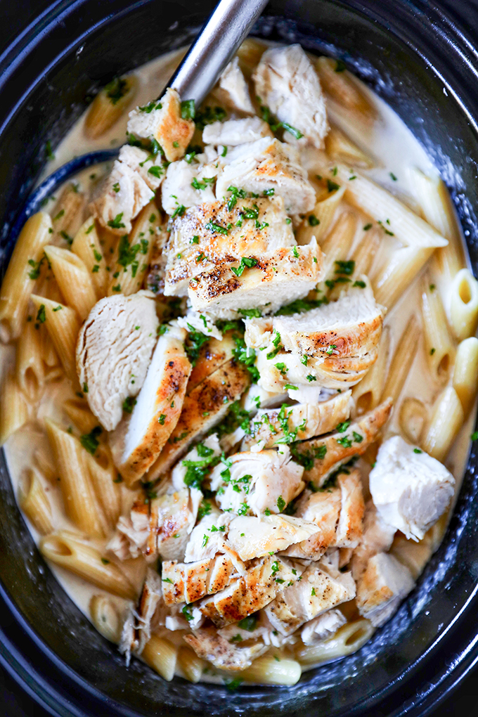 This Slow Cooker Chicken Alfredo is so easy to make. Tender juicy chicken breasts cooked right in a flavorful homemade alfredo sauce and the pasta cooks right in the slow cooke