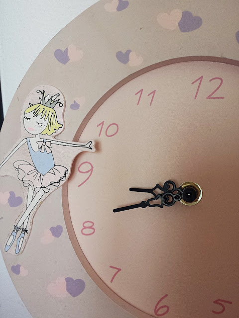 Różowy drewniany zegar z baletnicą.