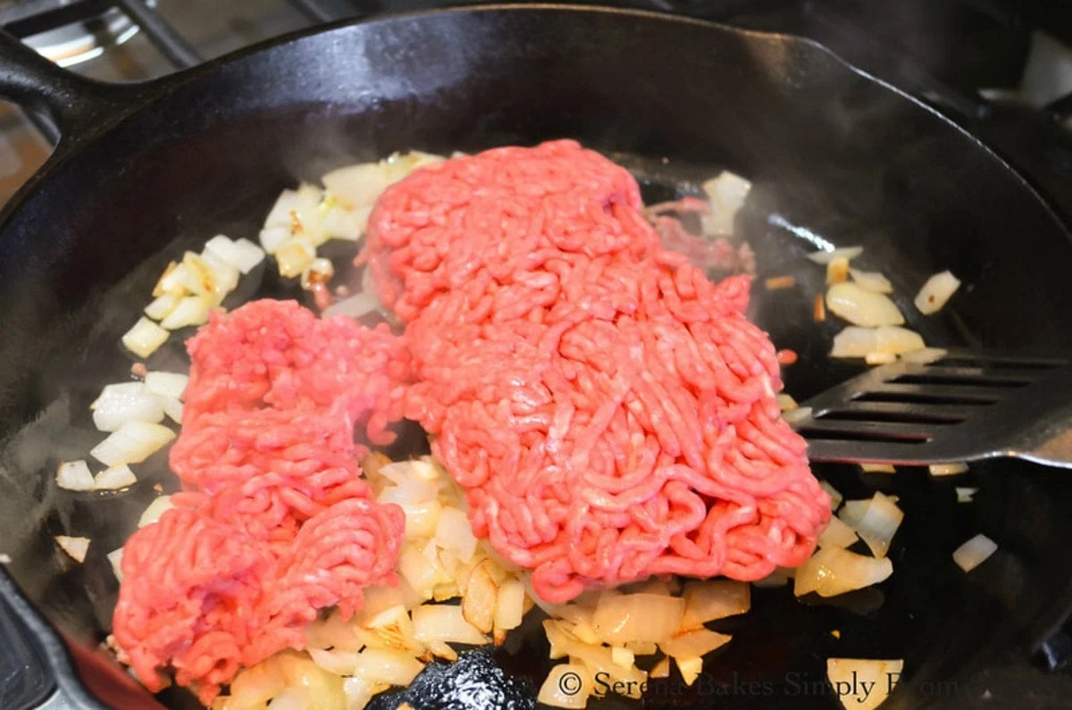 Ground Beef, Caramelized Onions in a cast iron skillet.