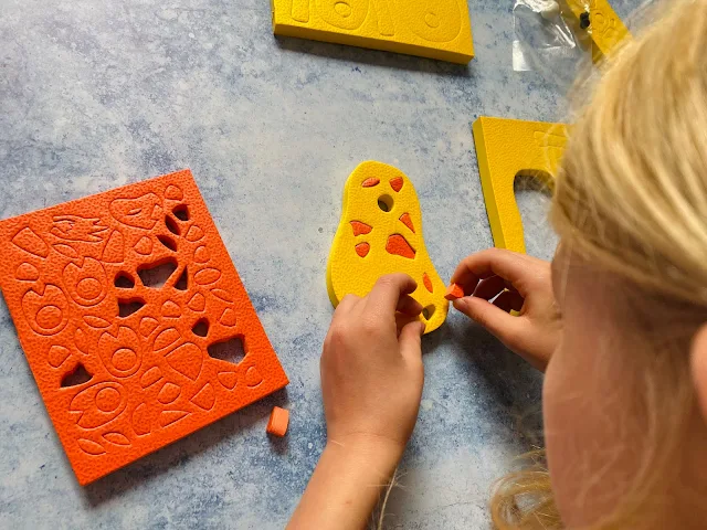 Overhead shot showing a child assembling the 3D foam puzzle giraffe