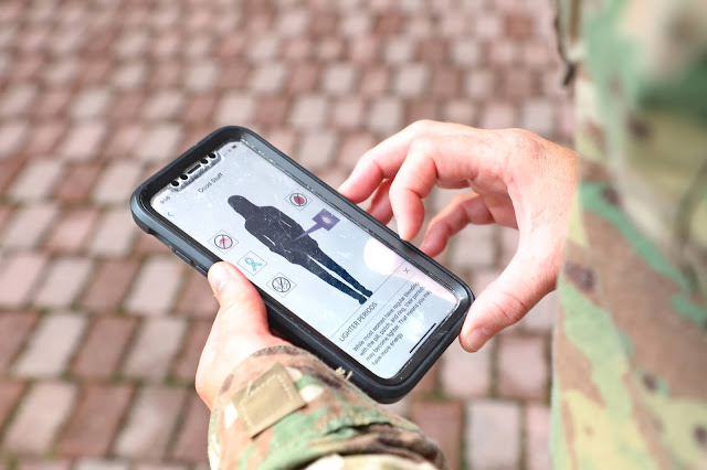 A hand holds a phone with an app on display