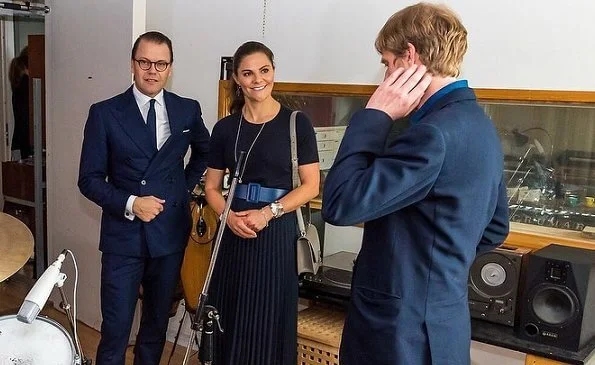 Crown Princess Victoria wore new pleated skirt from HM, navy duchess earrings from Ebba Brahe, and Rakel navy blue boots from af Klingberg