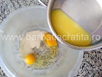 preparare reteta aluat gogosi la cuptor - amestecam in vas untul topit cu lapte si zahar cu drojdia si ouale