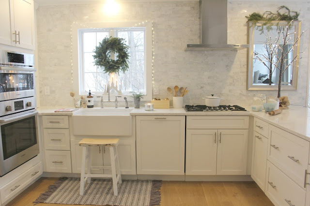 Holiday decorated white modern farmhouse kitchen with marble subway tile