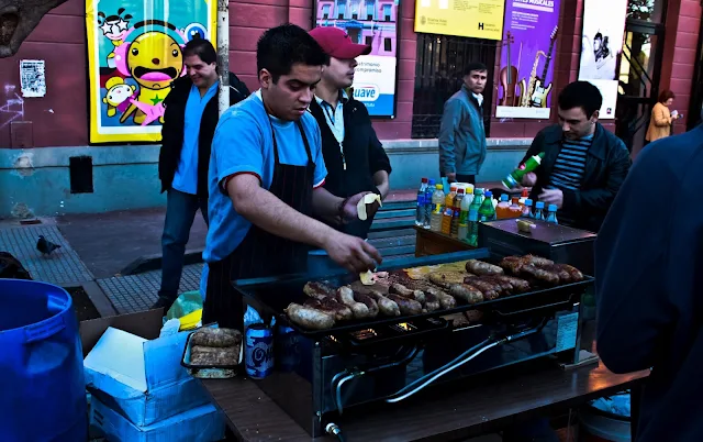 Parrilla con persona asando chorizos