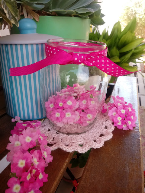 Bote de cristal con flores de verbena rosa