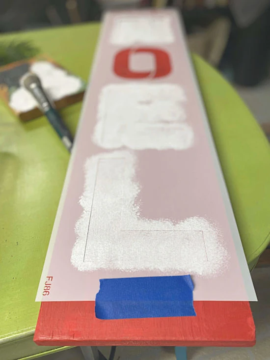 Noel stencil on a red board