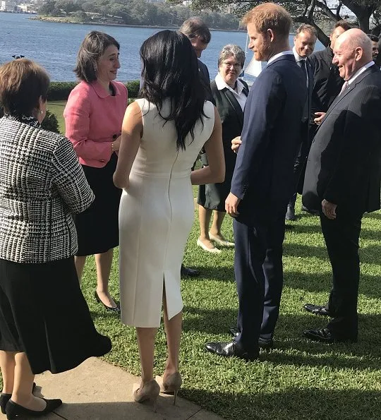 Meghan Markle wore a white Blessed dress by Australian designer Karen Gee, and she wore ​Stuart Weitzman suede pump in Haze Beige