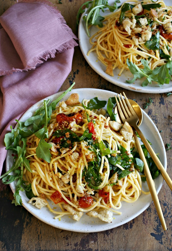 Recipe for a pasta dish with arugula, confit tomatoes and crispy torn bread.